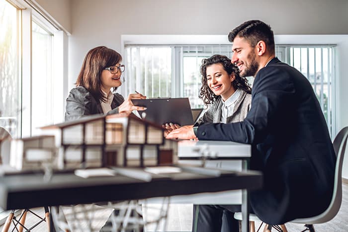 three individuals discussing investment property