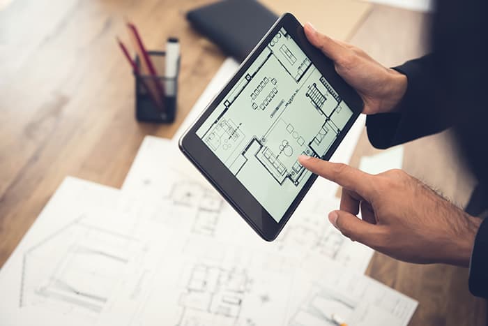 person holding tablet with a layout of an office
