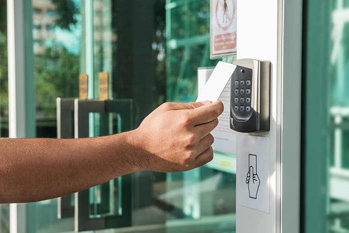 An individual scanning a card in order to enter a building