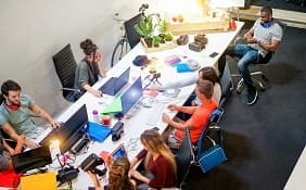 A group of individuals working on their devices in a shared space