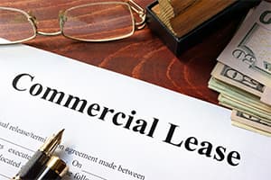 A snippet of a commercial lease with a pen, money, and a glasses near