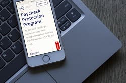 A cellphone with a screen showing paycheck protection program
