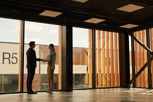 A real estate agent shaking hands with a client in an empty office space