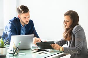 A man and a woman having a conversation at a desk