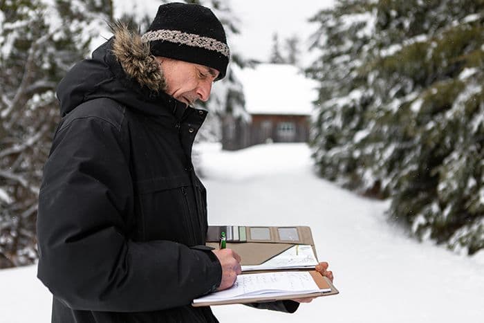 A man performing commercial property maintenance and writing on a notepad