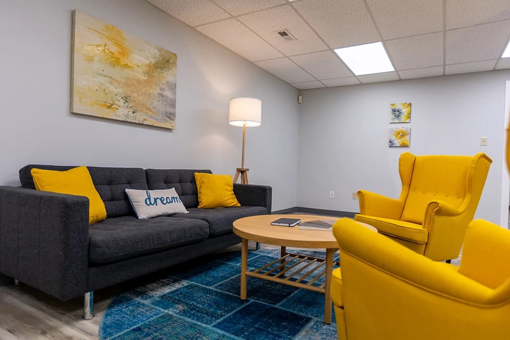 office lounge space with two chairs and one couch