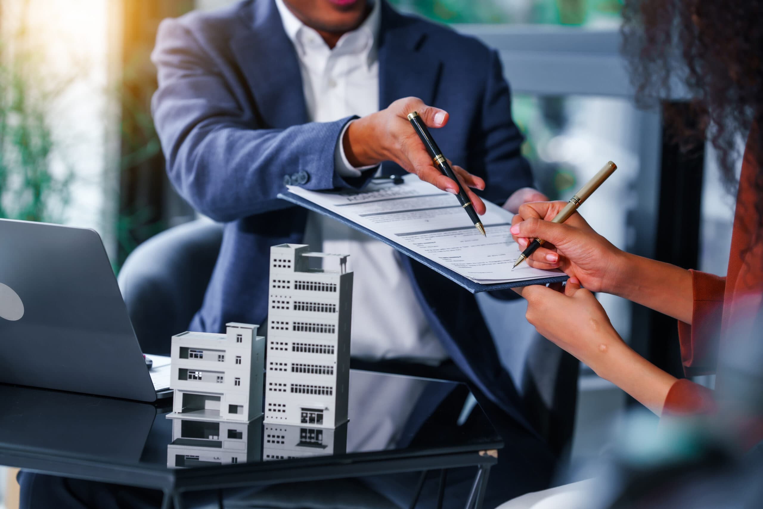 Two business people working on a document with one signing it