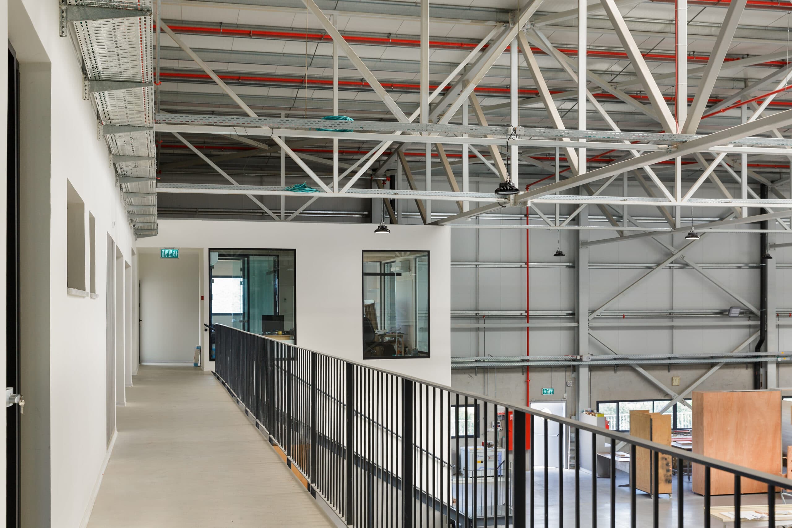 Image of the interior of a warehouse from a second story walkway overlooking a loading bay with a garage door opening