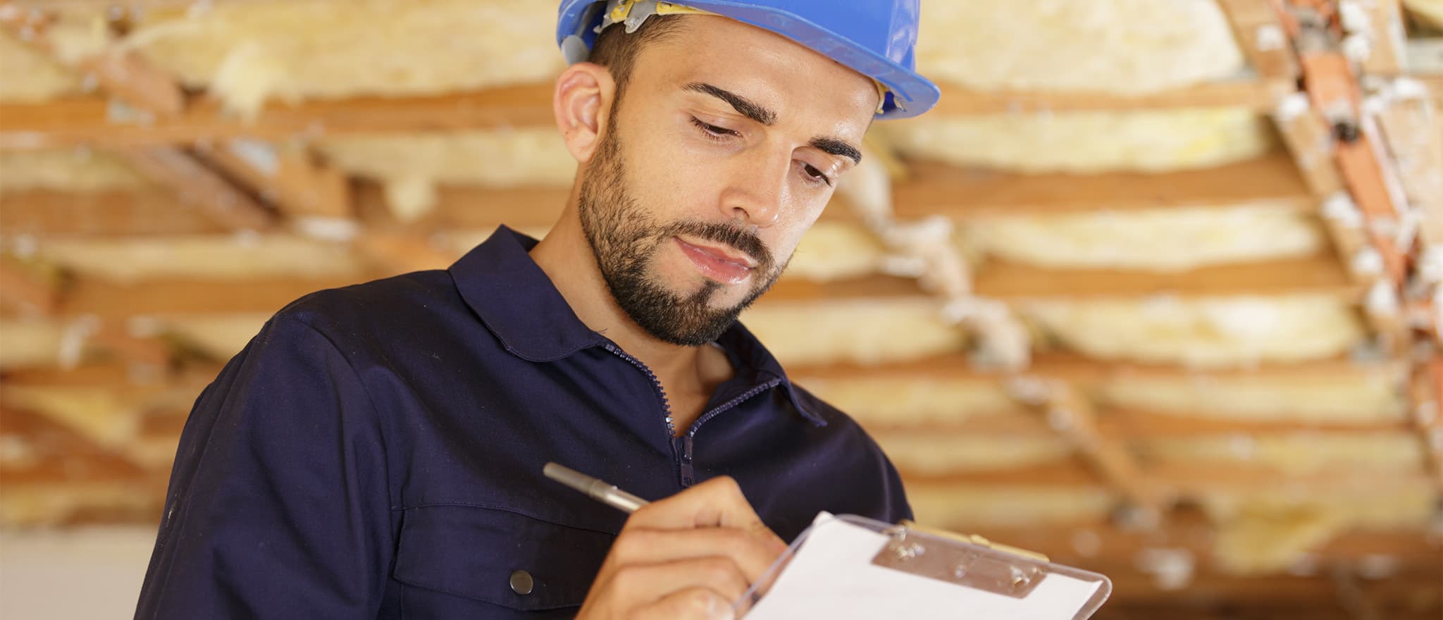 man writing on a notepad doing property maintenance