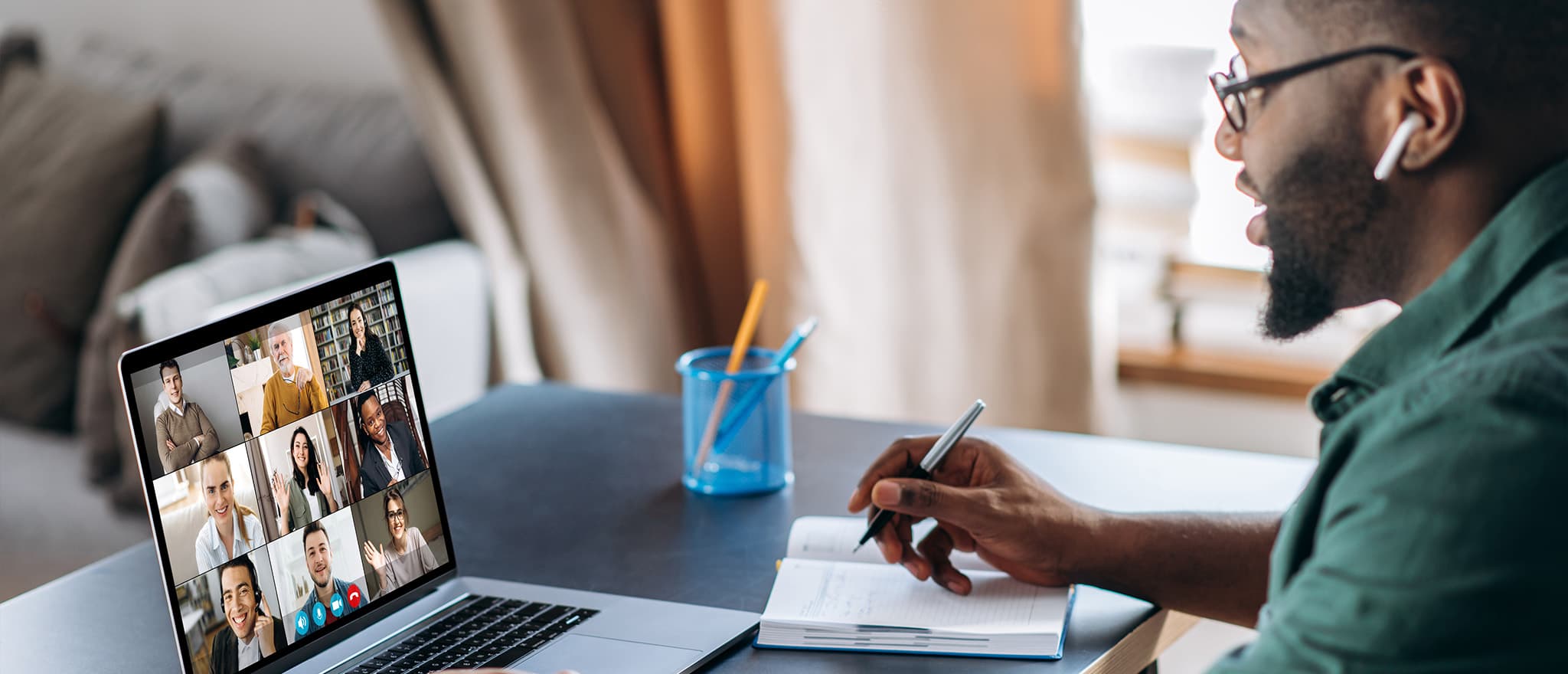 man talking to colleagues on a laptop