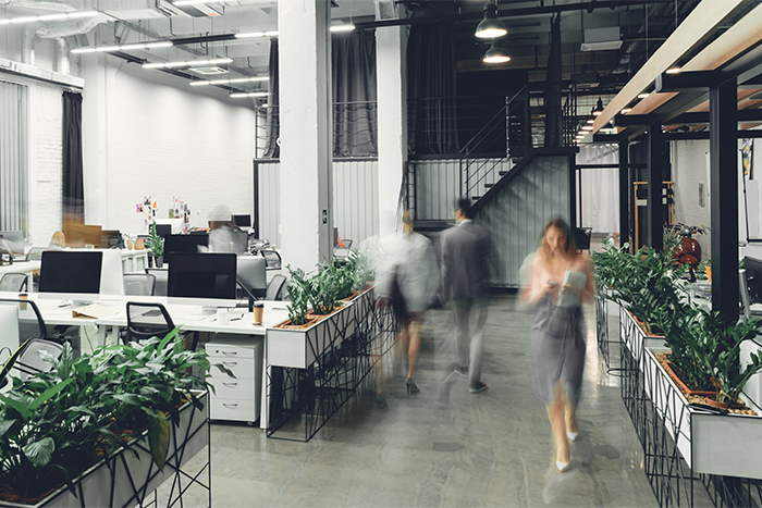 Interior of a modern office space with blurred business colleagues.