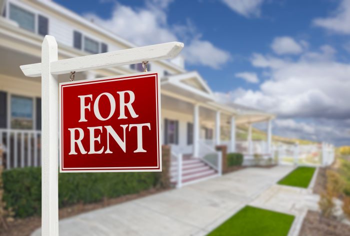 For rent rental property sign in front of a house.