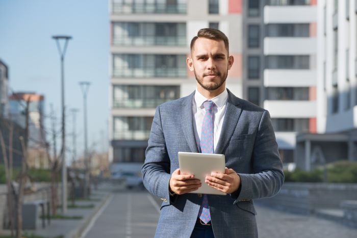 Commercial real estate property manager with tablet computer against a new building