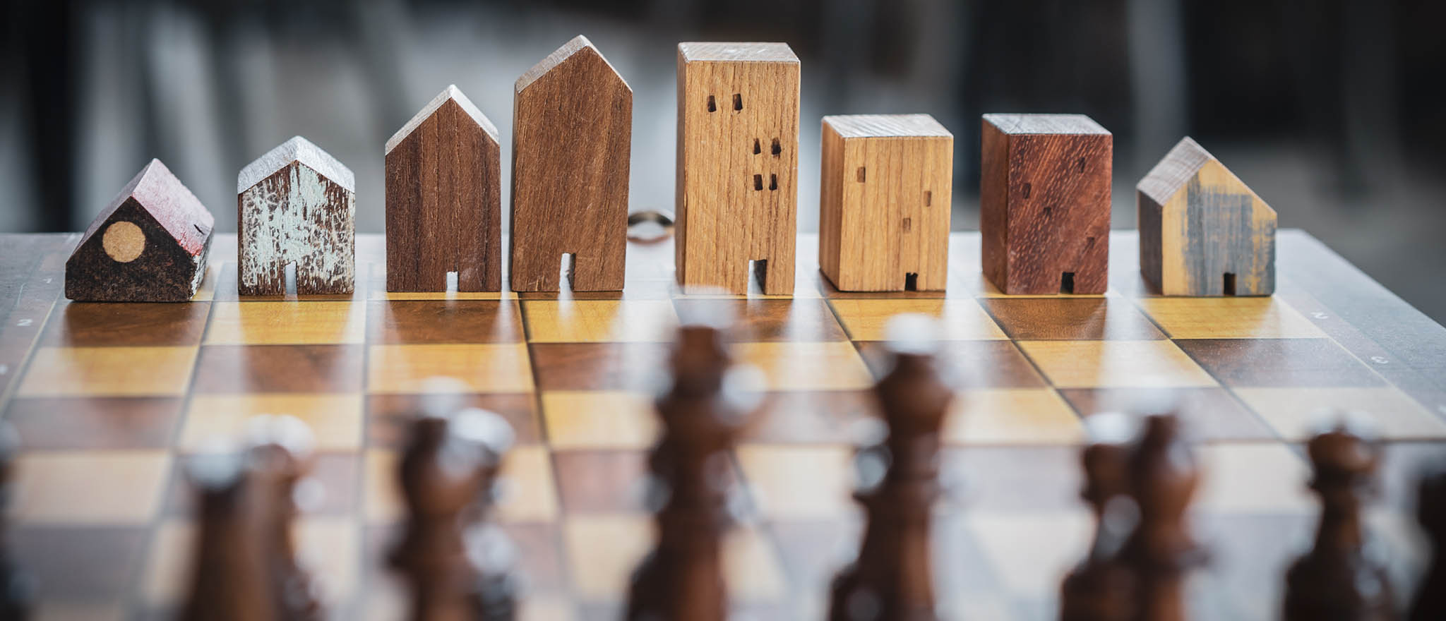 Chess board with pieces depicted as corporate real estate buildings